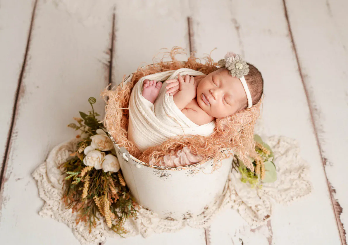 Newborn baby sleeping in a small flower-decorated basket