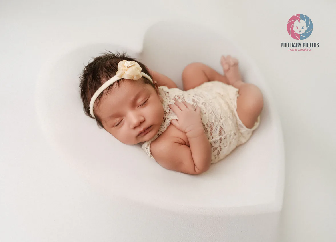 Newborn baby sleeping on a white curved seat