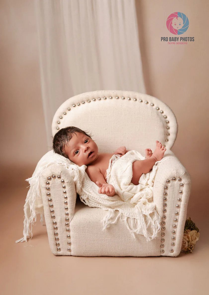 Sleeping baby resting in a small cream armchair
