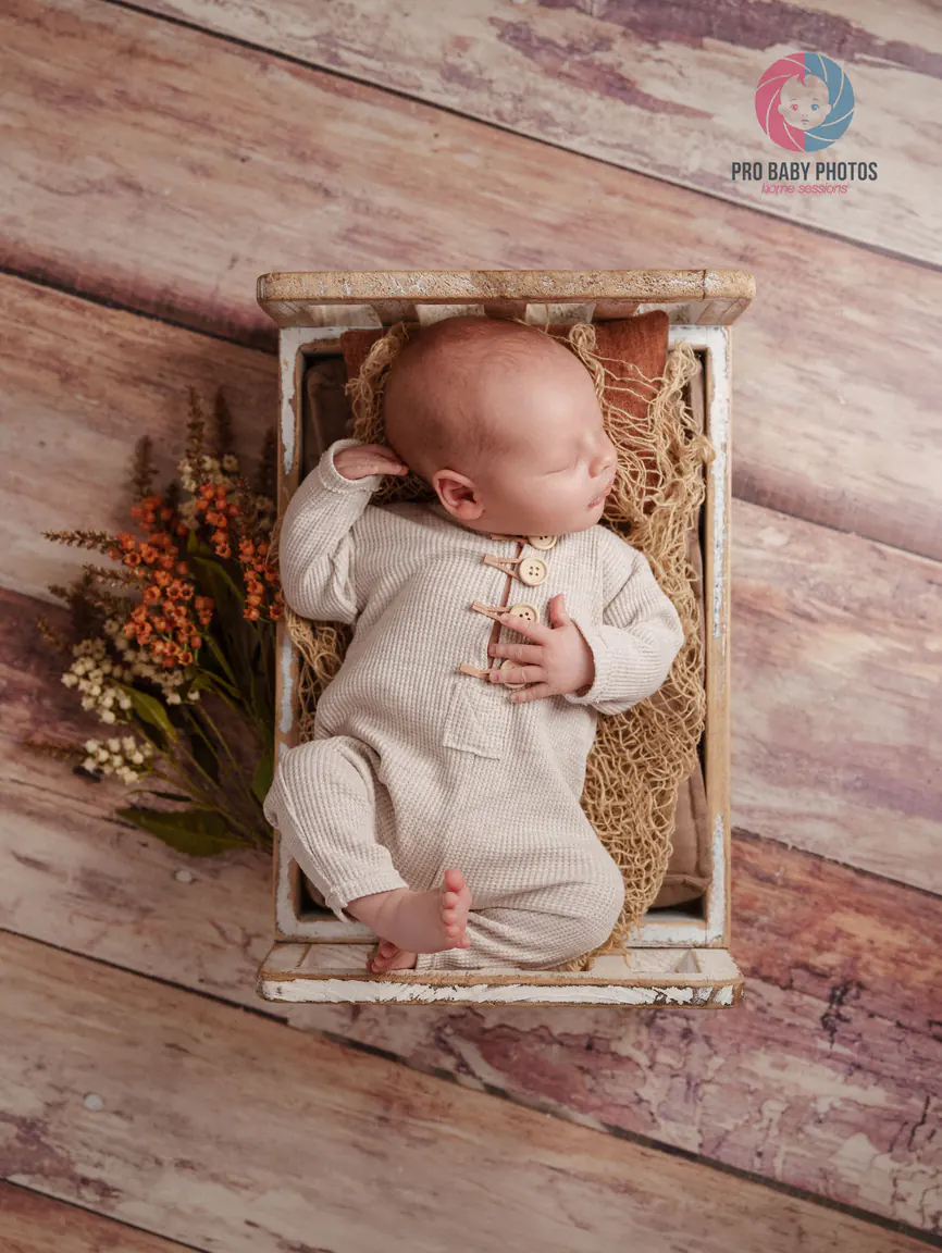 Newborn baby sleeping in a small wooden cradle