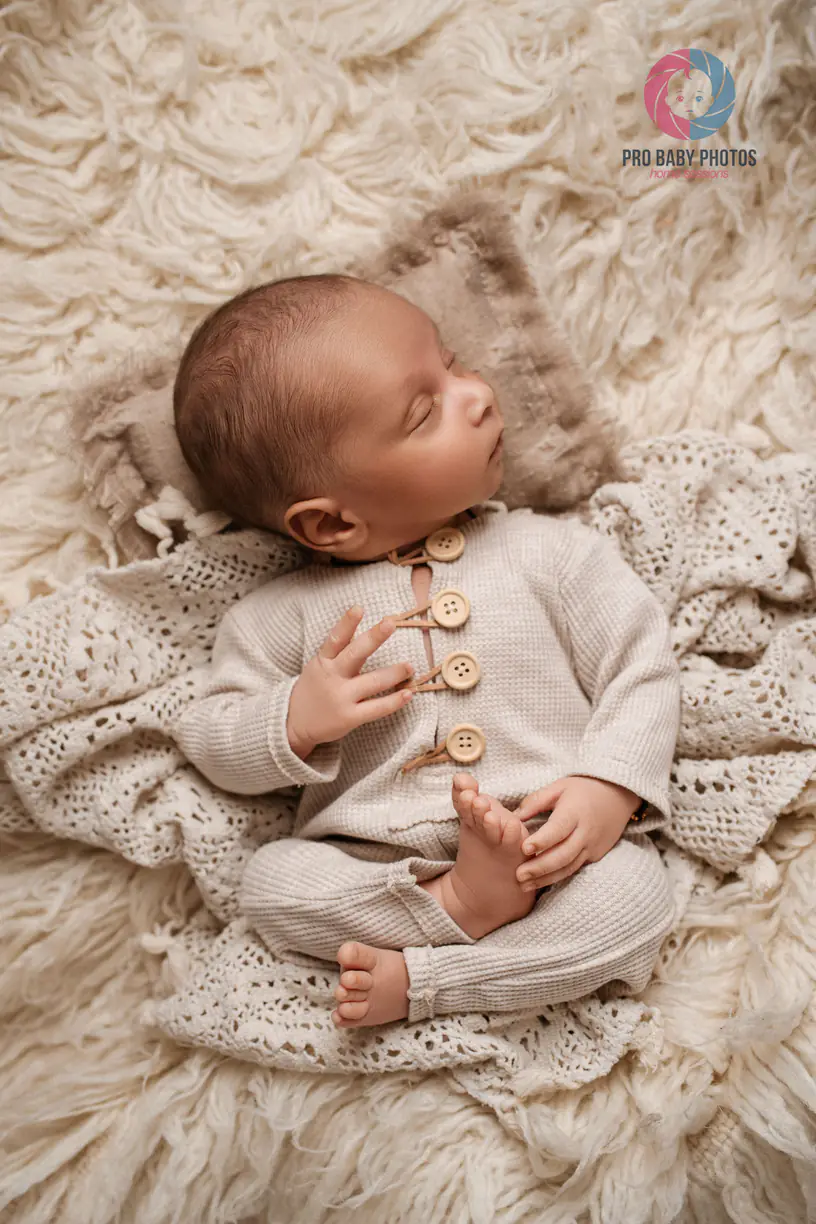 Sleeping newborn baby on a soft cream blanket